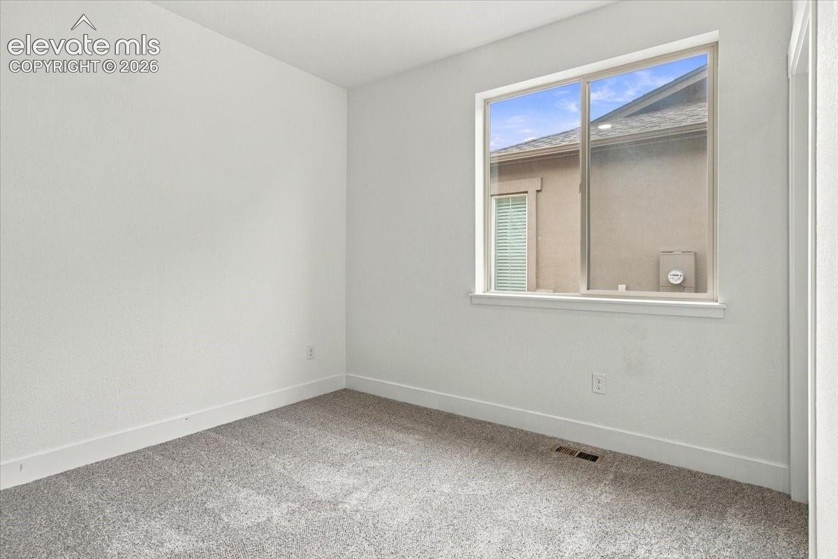 Neutral wall finishes, plush carpeting, and a sliding glass window