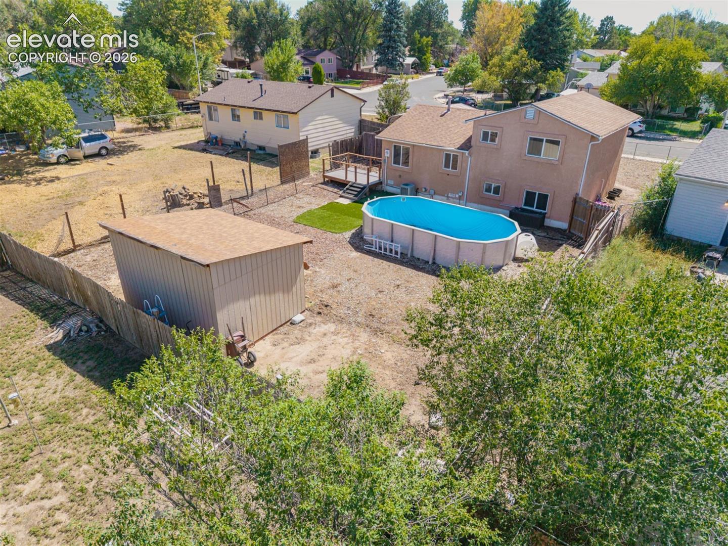 Backyard featuring an above-ground pool, a detached storage shed, fencing and a blank canvas for your projects. 