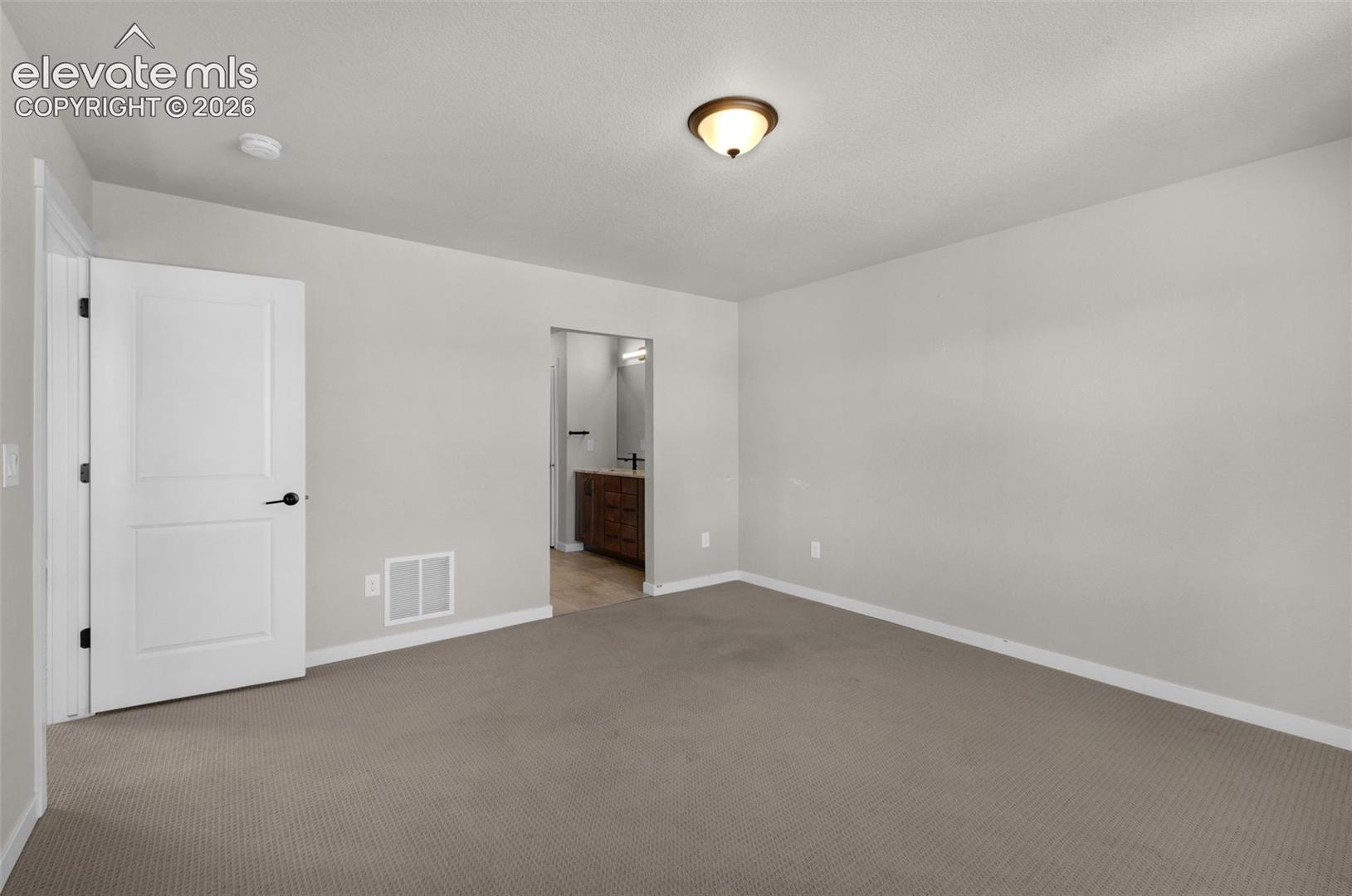 Neutral-toned carpeting, modern interior doors with black hardware, and a semi-flush mount ceiling fixture
