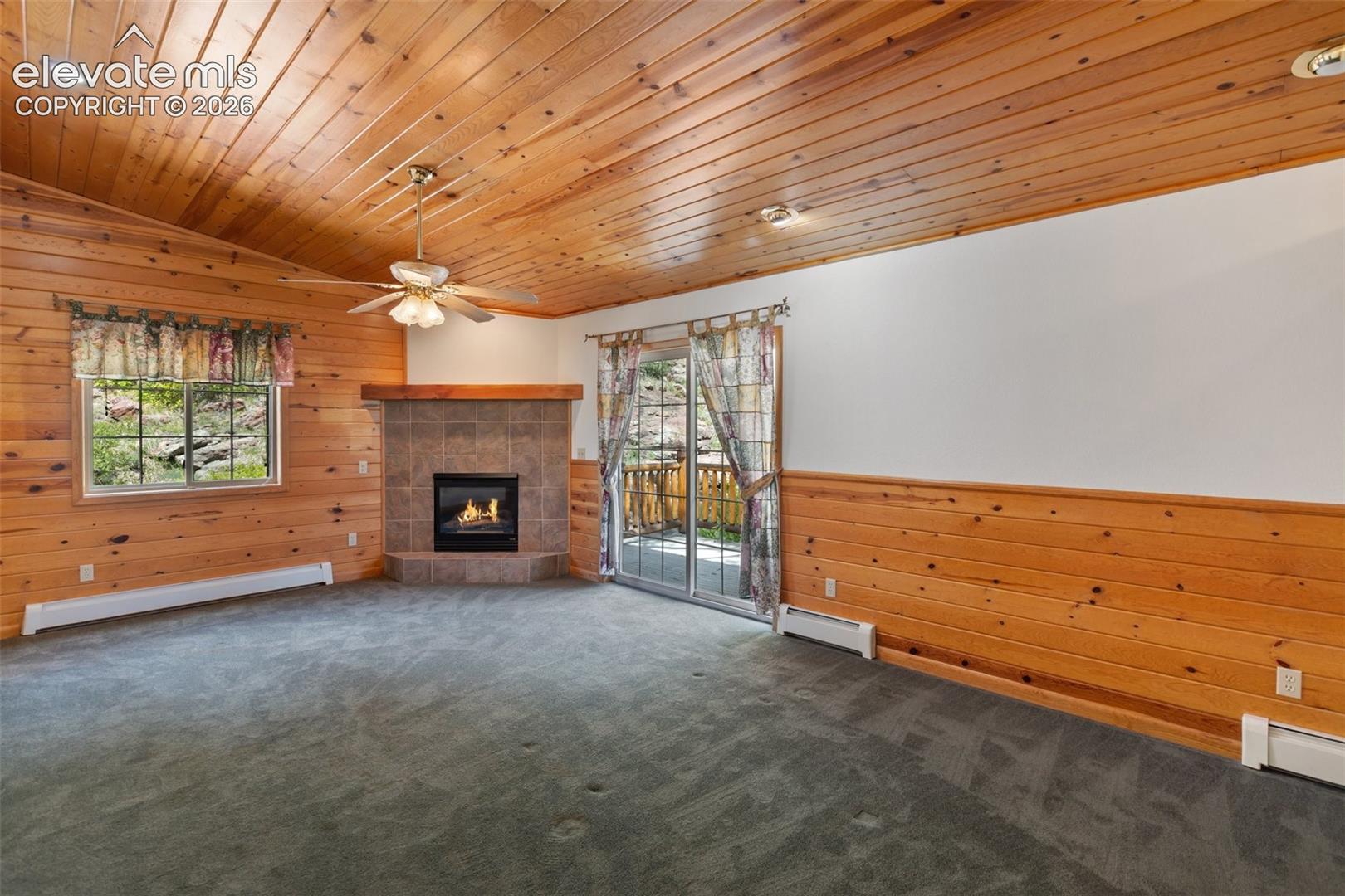 Primary bedroom with a walk-out to the outdoors and a cozy fireplace for year-round comfort.