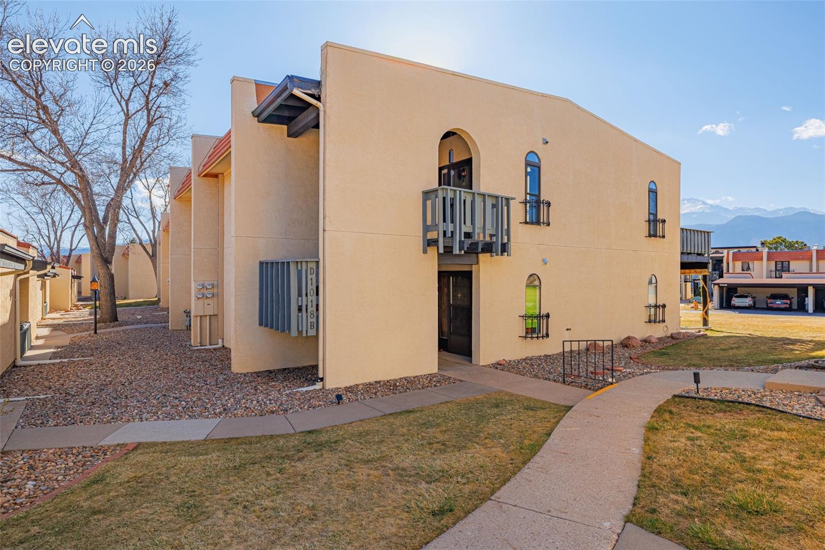 Stucco exterior with arched windows, wrought iron window boxes, and a second-story balcony