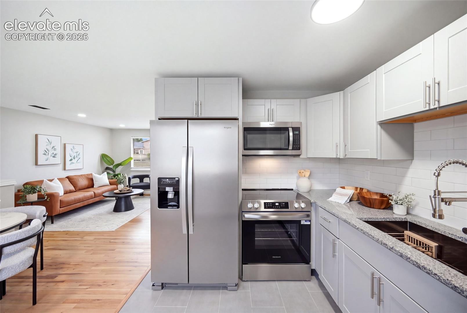 Kitchen featuring stainless steel appliances, light gray cabinetry, and a subway tile backsplash