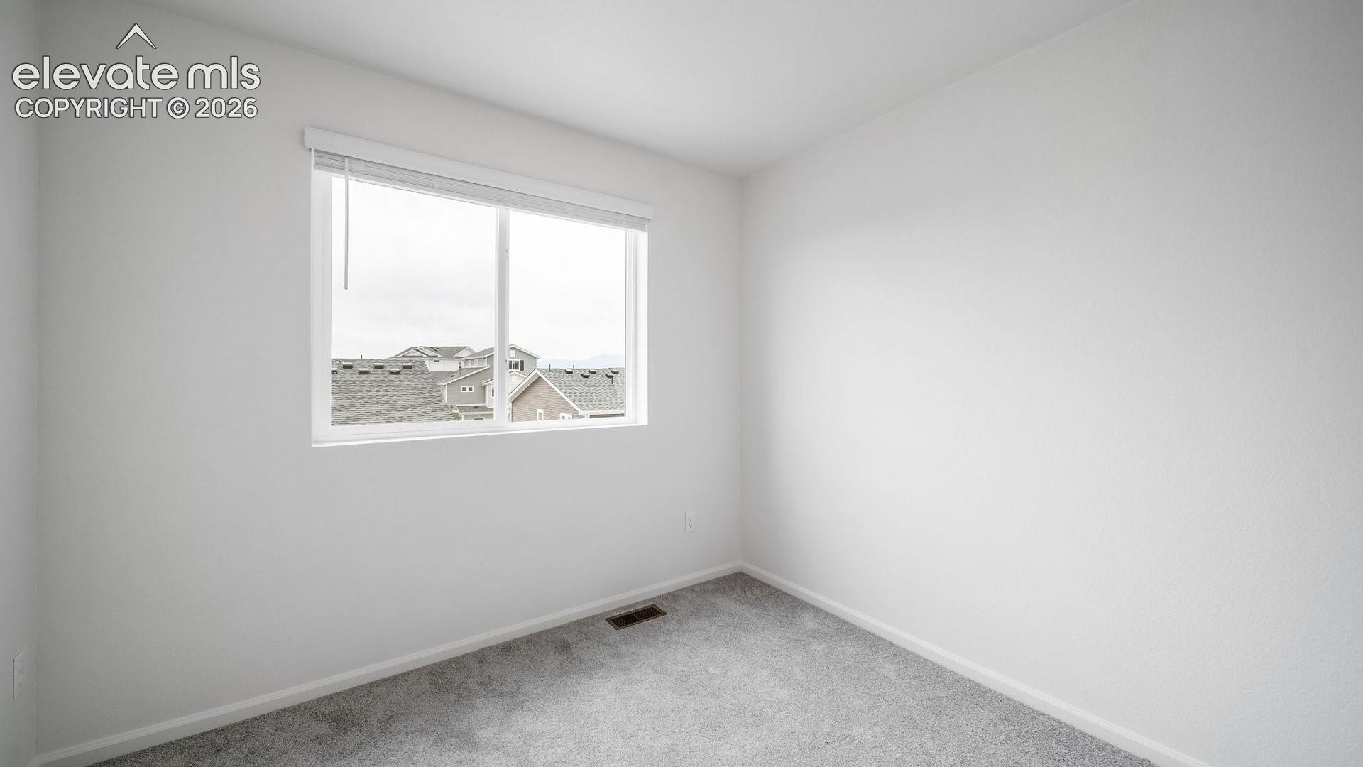 White walls with gray carpeting and a large window
*photos of a model home*