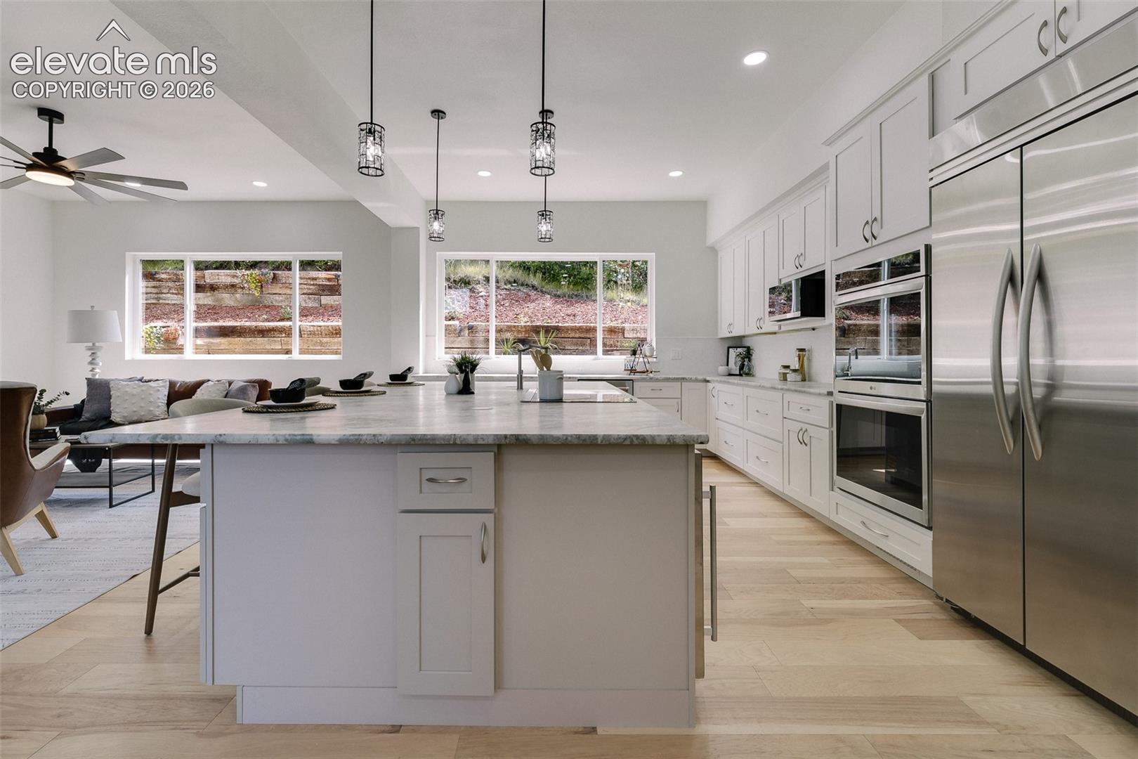 Expanded Island with leathered granite countertop, pendant lighting, and breakfast bar.