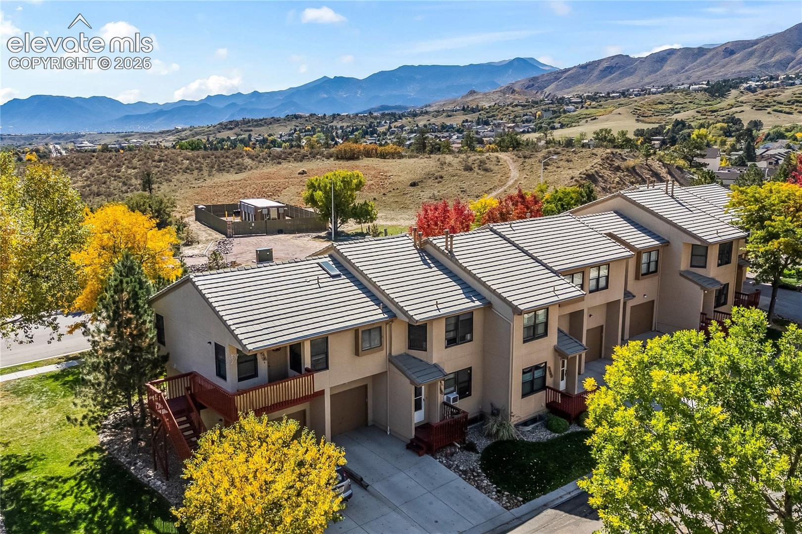 Terraced townhome-style residences with attached garages and tile roofing