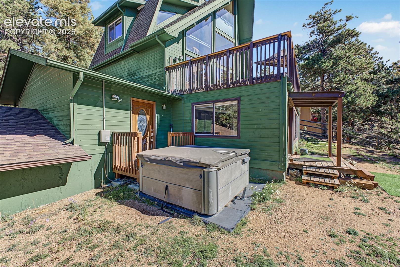 Multi-level green siding exterior with a second-story balcony