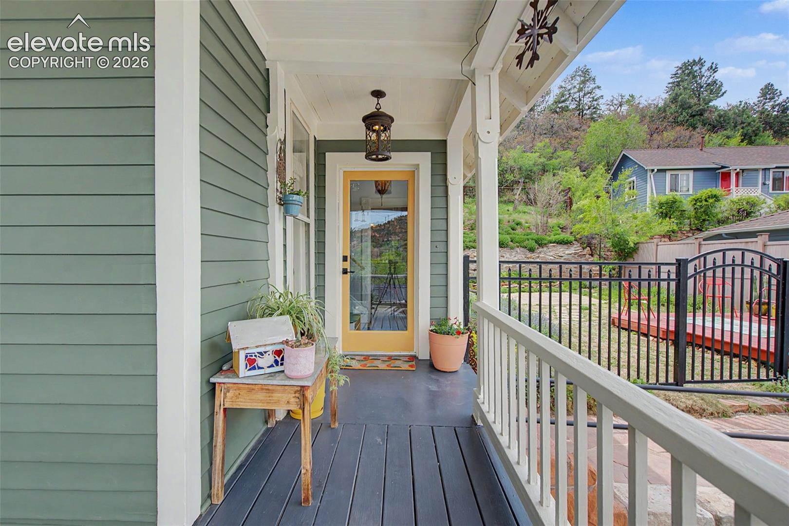 Covered front porch entrance to main home featuring a full-light entry door