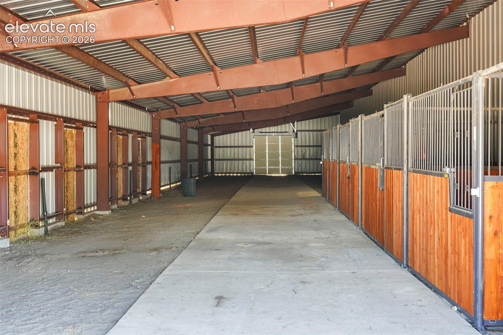 Metal-framed structure featuring multiple stalls with wood-finish paneling and metal grating