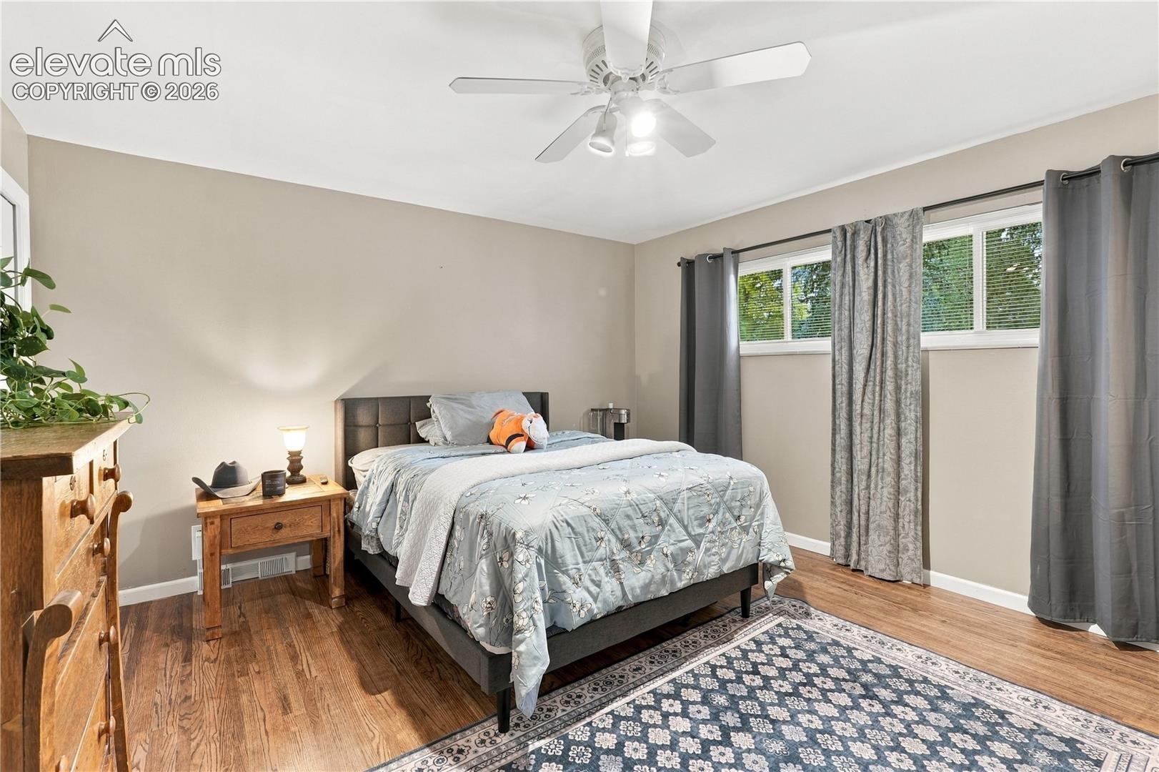 Neutral wall tones, wood-finish flooring, dual-pane windows, and a ceiling fan with integrated lighting