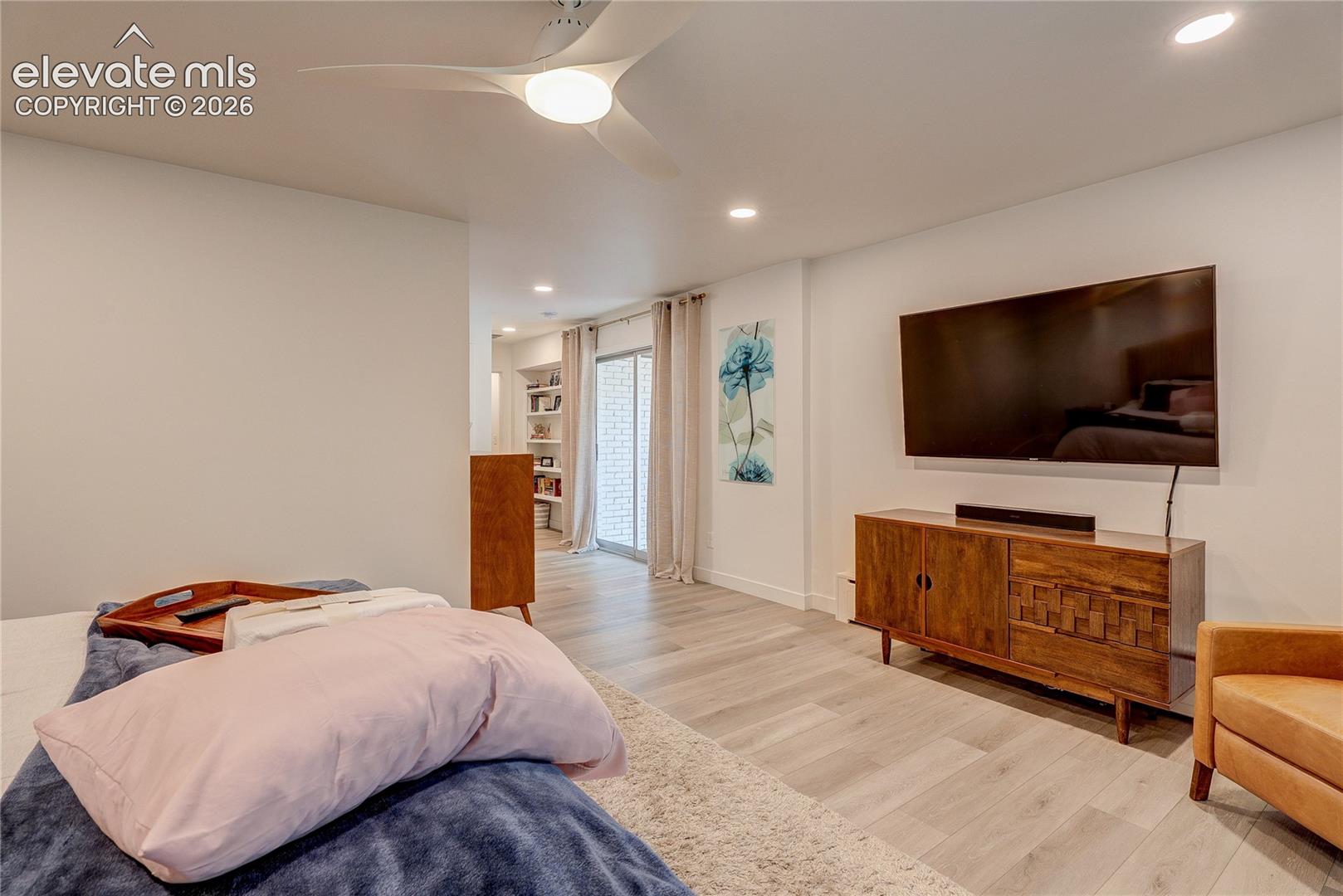 Recessed lighting, light wood-finish flooring, ceiling fan with integrated light, and built-in shelving