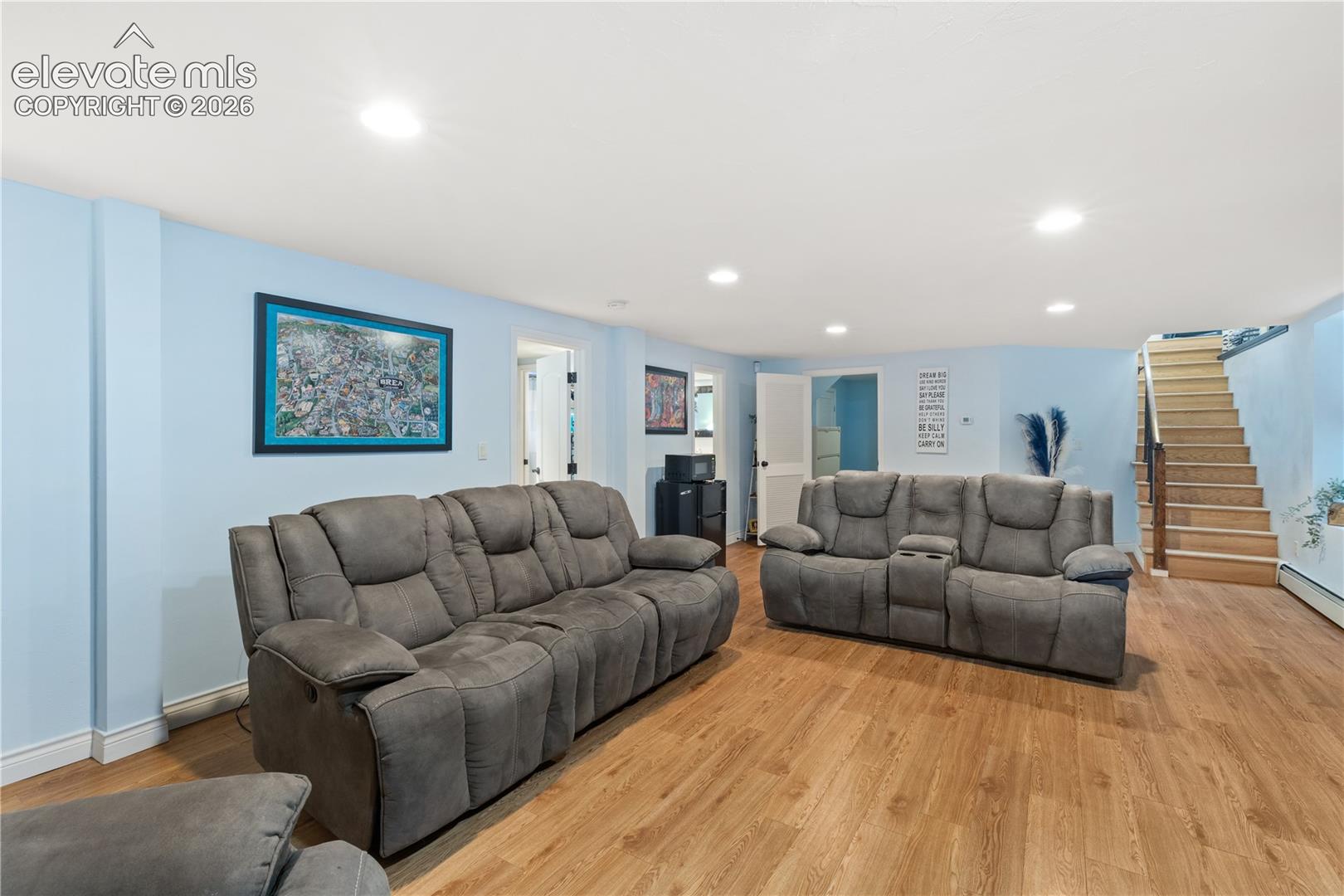 Open-concept room featuring wood-finish flooring, light blue walls, and recessed lighting