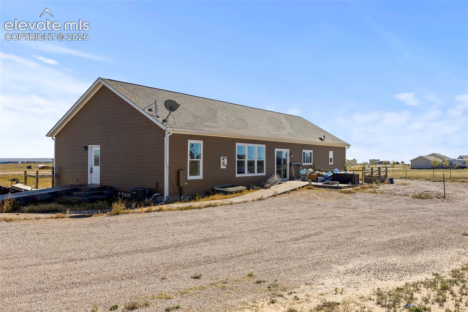Single-story residence featuring horizontal lap siding, a gable roof, and a gravel driveway