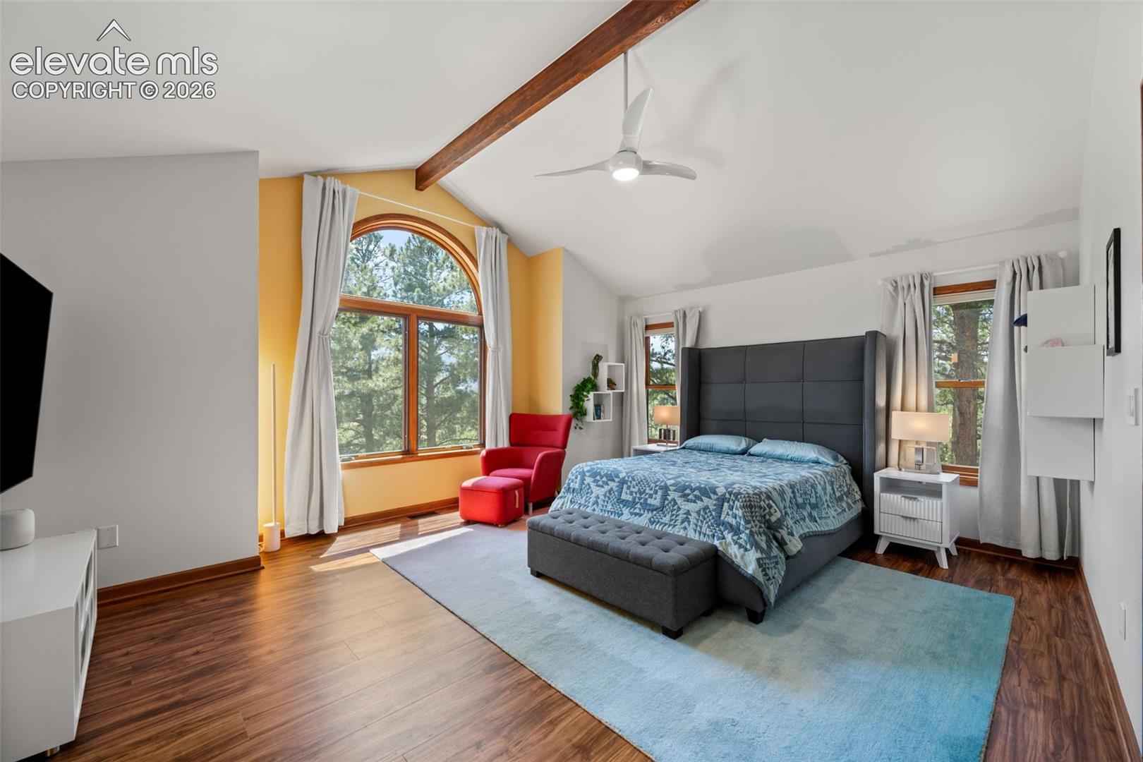Vaulted ceiling featuring an exposed wood beam and a contemporary ceiling fan