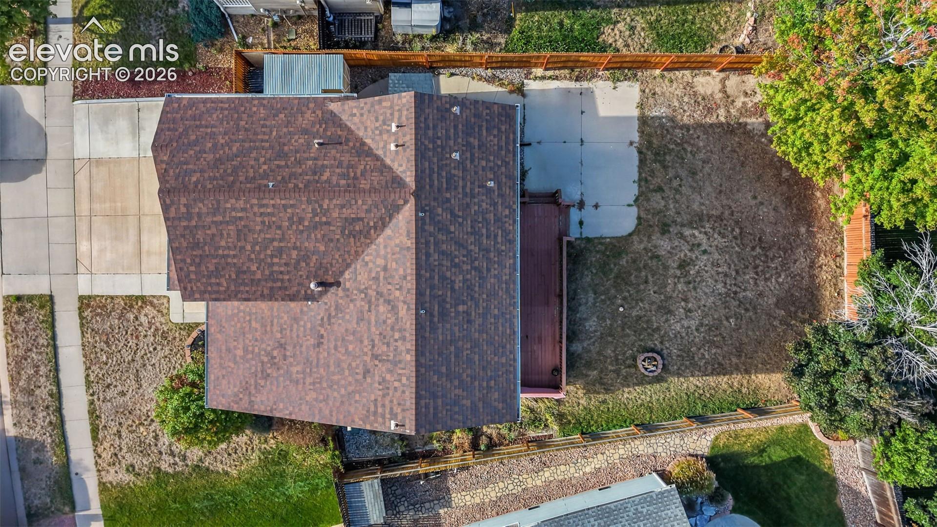Asphalt shingle roof, concrete driveway, concrete patio, wood deck, fenced backyard