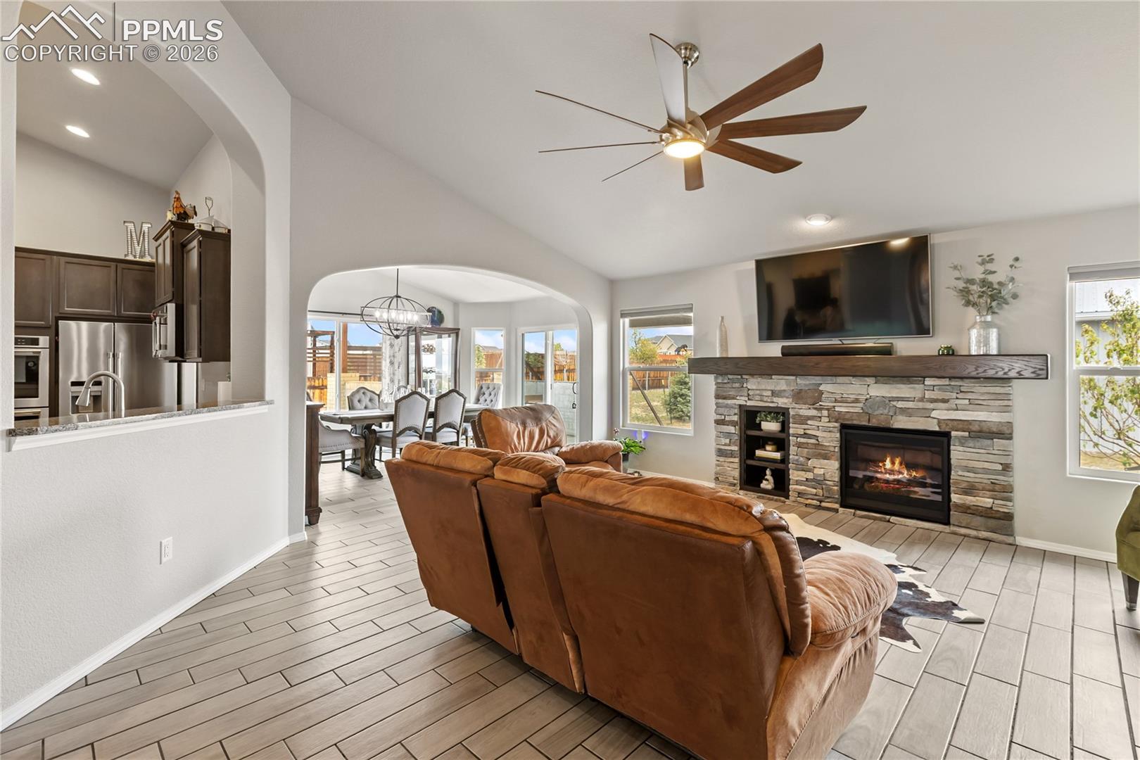 Living area featuring a stacked stone fireplace with an integrated mantel and shelving