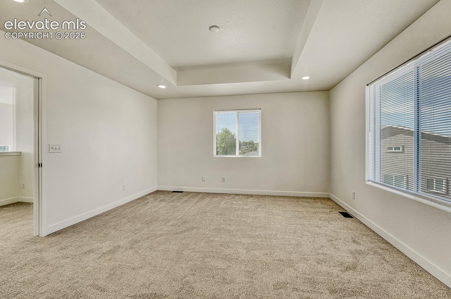 Primary bedroom features tray ceiling