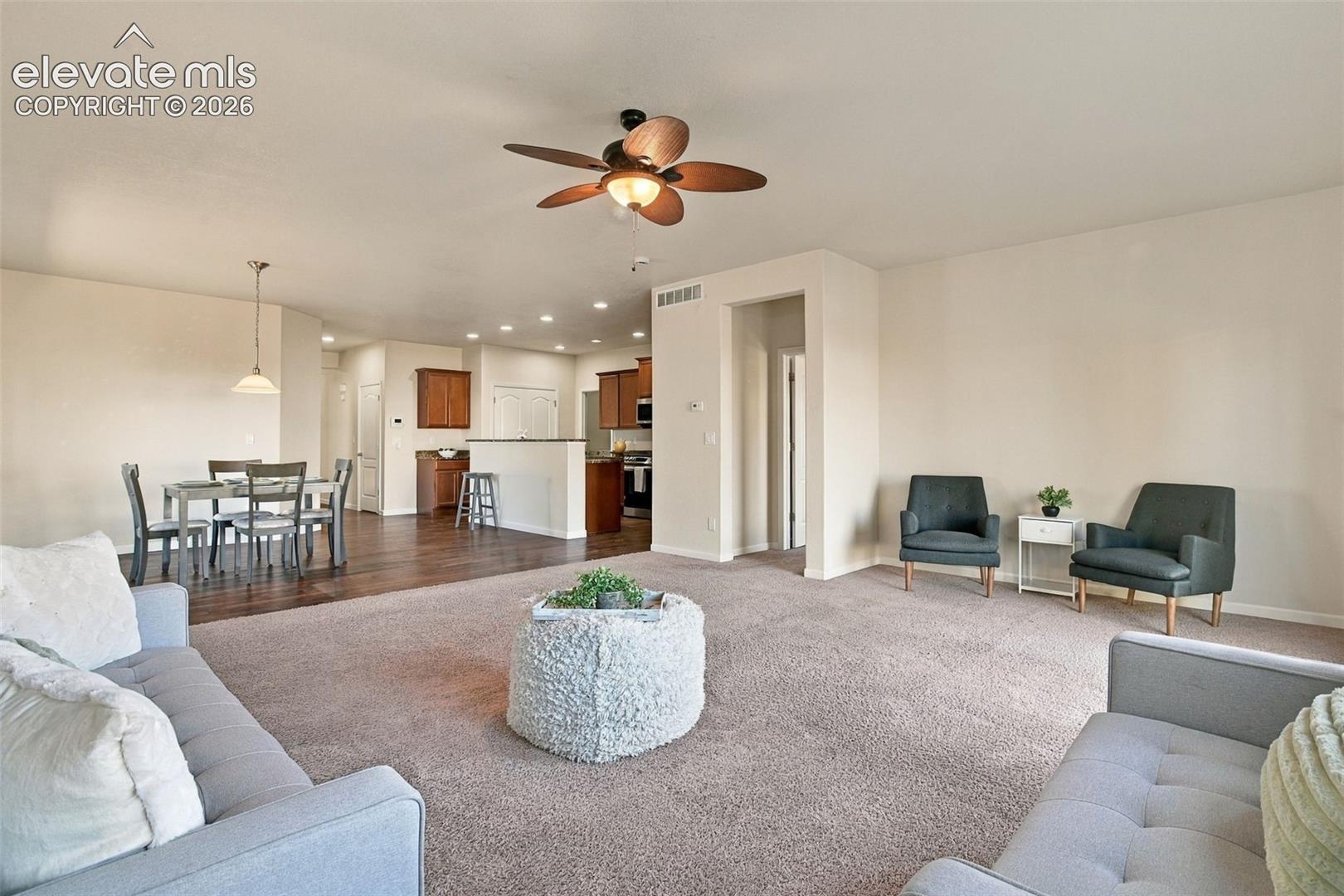 Open interior featuring neutral wall tones, wood-finish flooring, recessed lighting, and a ceiling fan with integrated light fixture