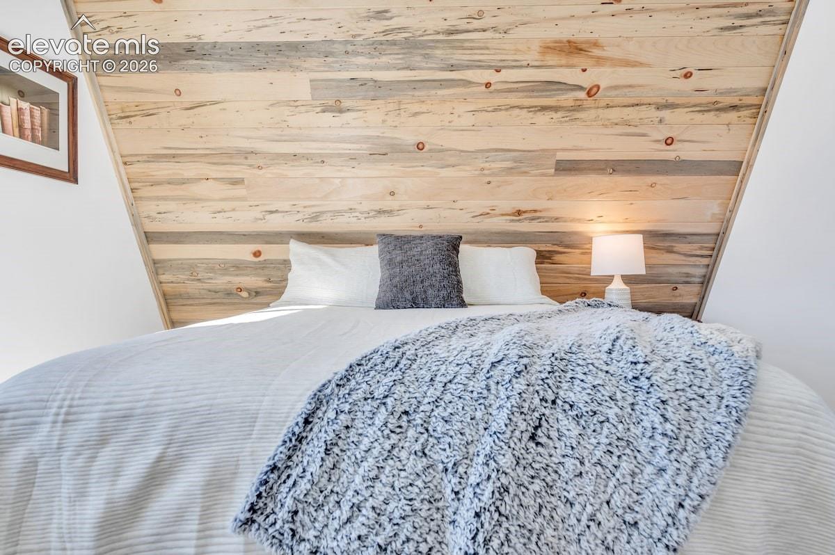 Vaulted ceiling featuring natural wood-plank paneling and angular architectural lines