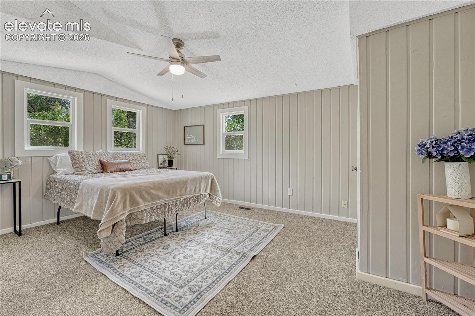 Light-colored carpeted flooring with vertical paneling on walls