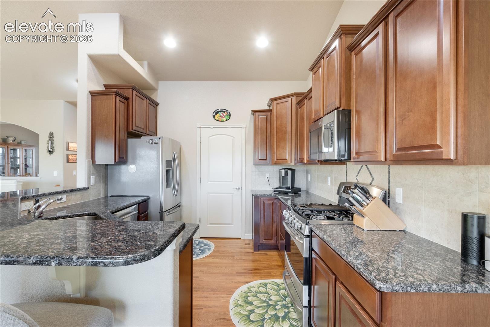 Kitchen stone countertops, breakfast bar, large pantry, open to the Living Room and walks out to the covered deck