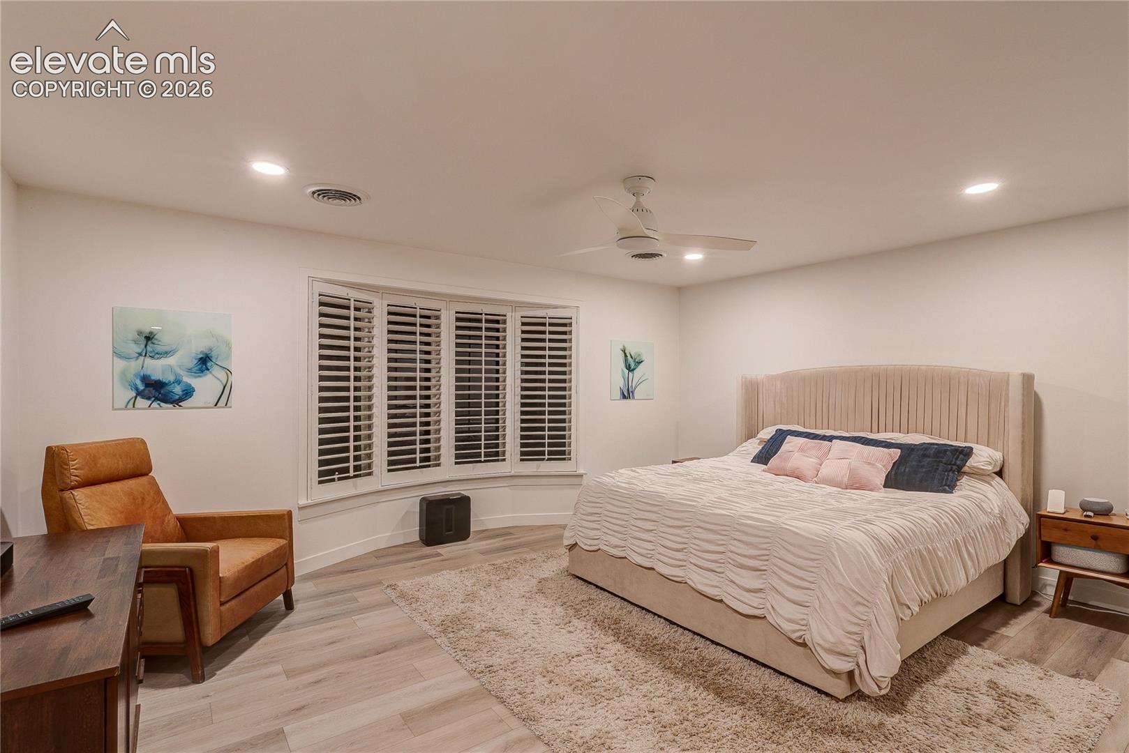 Recessed lighting, ceiling fan, wood-finish flooring, bay window with plantation shutters