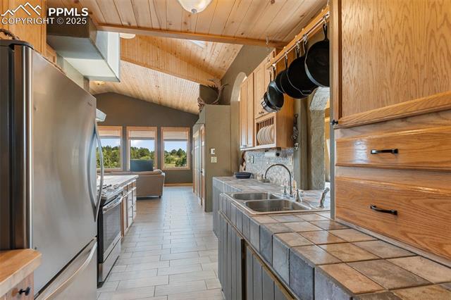 Tiled countertops and stainless steel appliances. 