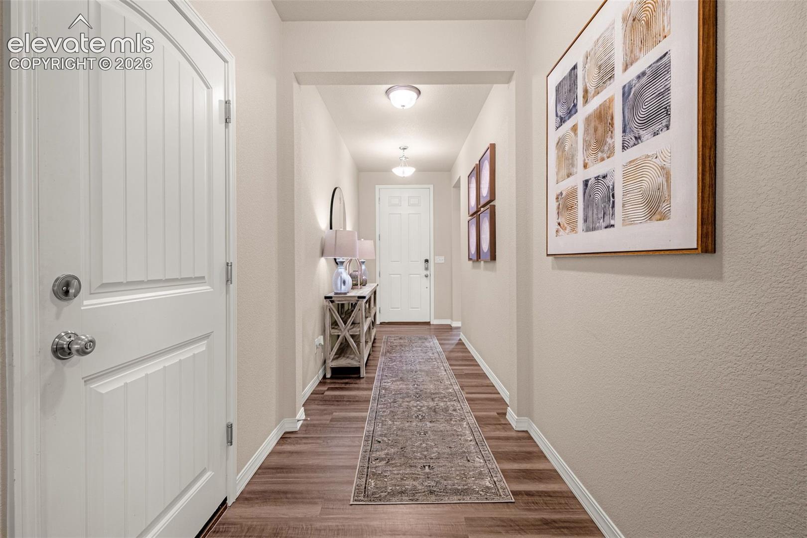 Wood-finish flooring throughout, framed entryway, and ceiling-mounted lighting fixtures