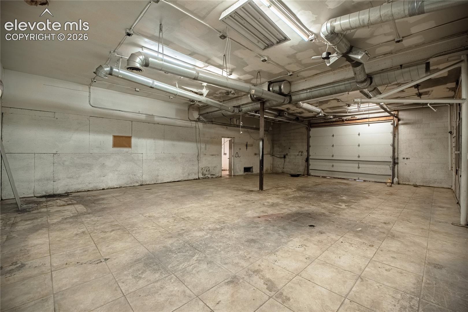 Open space featuring concrete block walls and square floor tiles