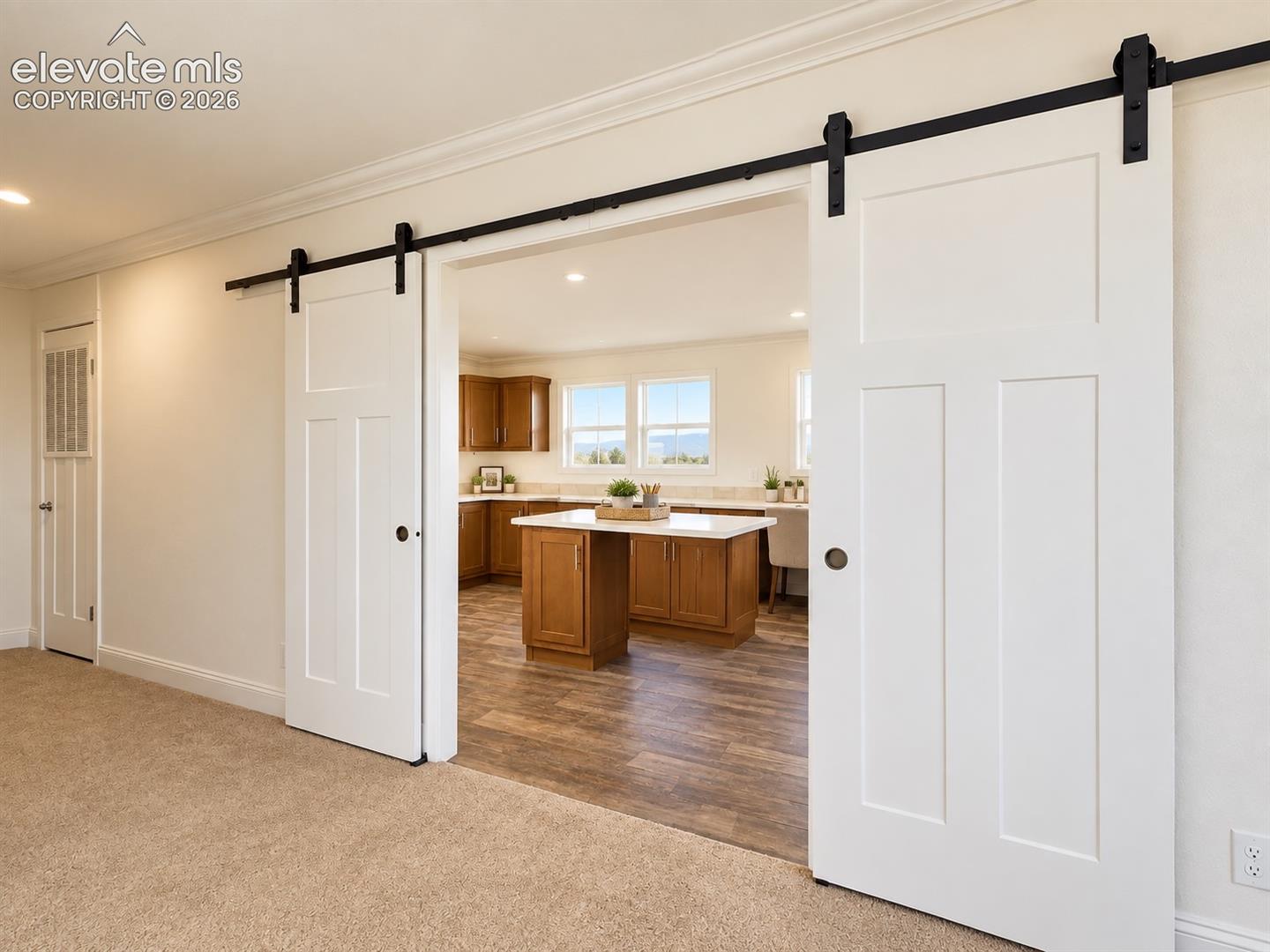 Family Room / Laundry Connection – Oversized barn doors create a distinctive transition from the family room into the expansive laundry and multipurpose area, allowing the two spaces to function together or separately.