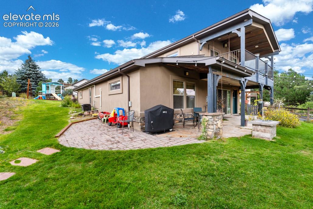 Stucco exterior with stone accents, a multi-level deck, a covered patio, and a paver patio