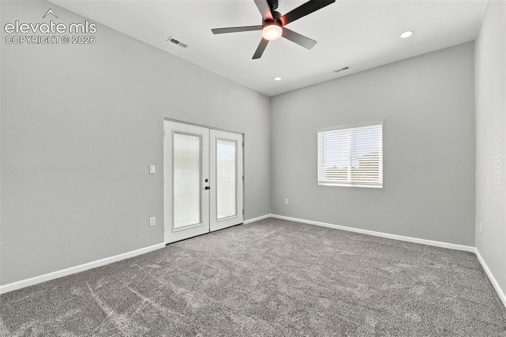 Vaulted ceiling with a ceiling fan, recessed lighting, double French doors, and a window with blinds