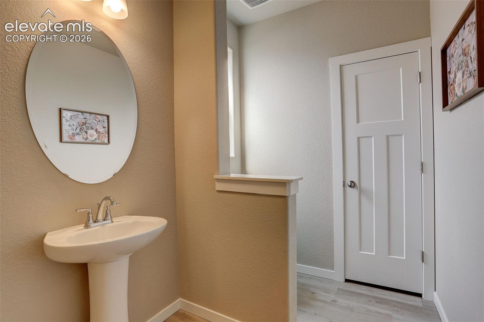 Main level Bathroom, pony wall, with pedestal sink, and linen closet - this bathroom is located  near the office, foyer and basement access