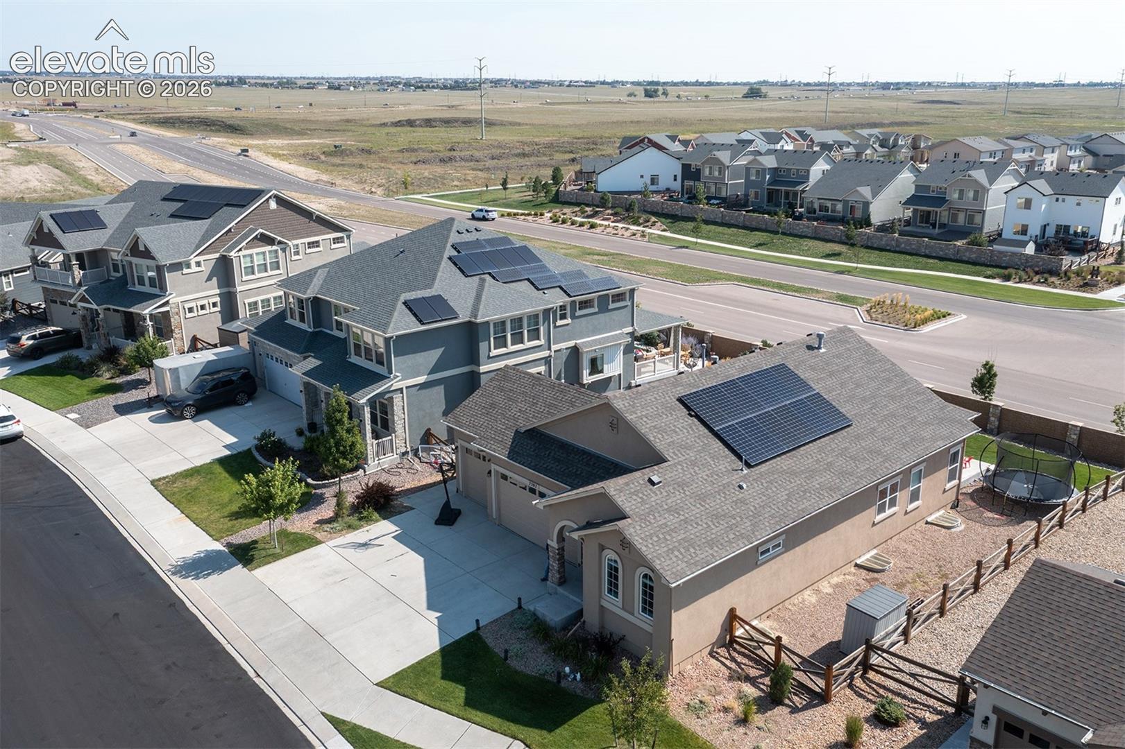 Residential property with solar panels, attached garage, and paved driveway