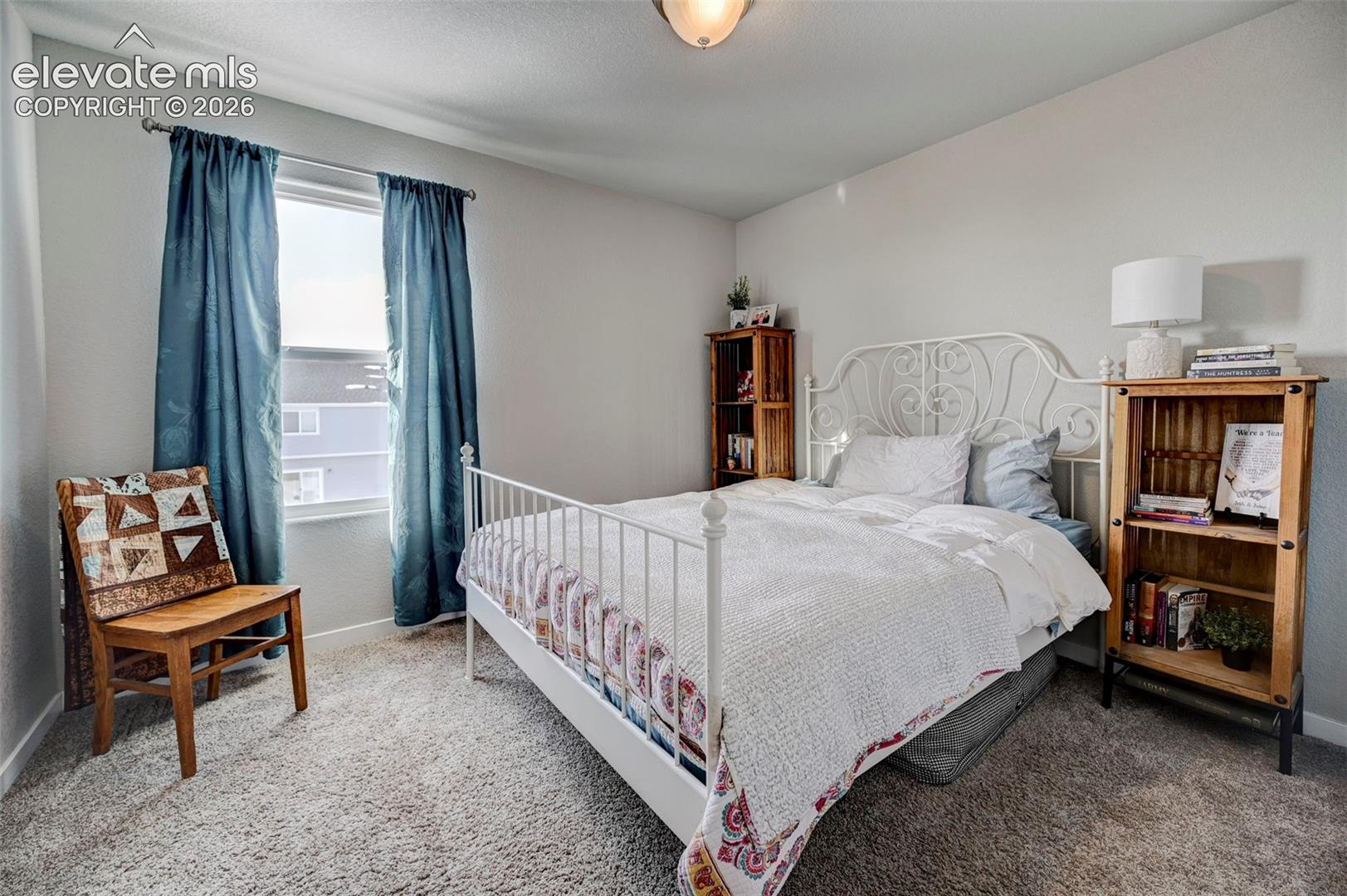 Neutral-toned interior room featuring wall-to-wall carpeting, a single-pane window, and a central ceiling-mounted light fixture
