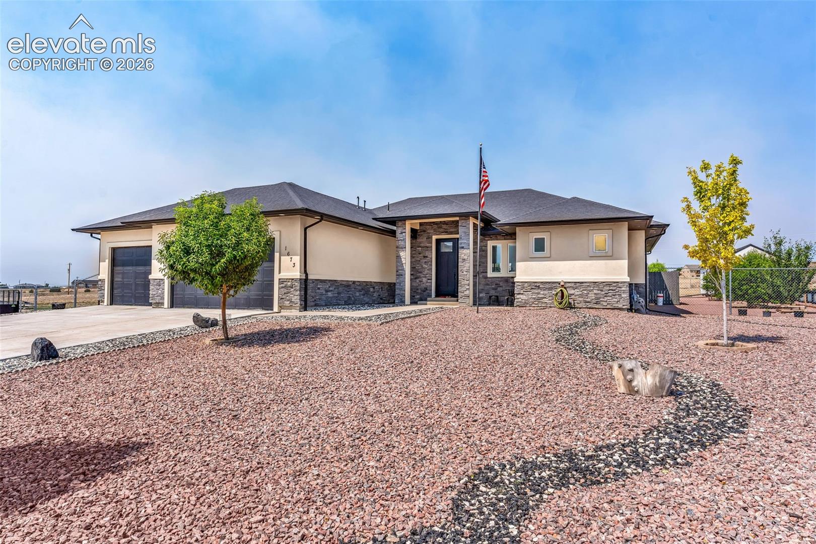 Welcome to this exceptional custom-style ranch home located on the desirable north side of Pueblo West. Built in 2021, this move-in-ready residence offers 3 bedrooms, 2 bathrooms, and a spacious 3-car attached garage, all situated on 1.07 fully fenced acres with xeriscape landscaping. Designed with modern elegance and everyday functionality in mind, the open-concept floor plan showcases soaring vaulted ceilings, abundant natural light, and contemporary finishes throughout. The kitchen features granite countertops, recessed lighting, and a built-in corner pantry, creating an ideal space for both entertaining and daily living. The private primary suite serves as a relaxing retreat with a spacious walk-in closet and an ensuite bath featuring dual vanities. Adding exceptional value and versatility are two detached outbuildings. A 10' x 20' utility building and a 16' x 24' storage building with built-in shelving providing abundant space for gardening supplies, tools, recreational equipment, workshop use, or additional storage. Ideally located just minutes from Lake Pueblo, Interstate 25, and Highway 50, this home offers convenient access while maintaining the privacy and space. This beautifully maintained property presents a rare opportunity to enjoy modern construction, thoughtful upgrades, and over an acre of usable land in Pueblo West.