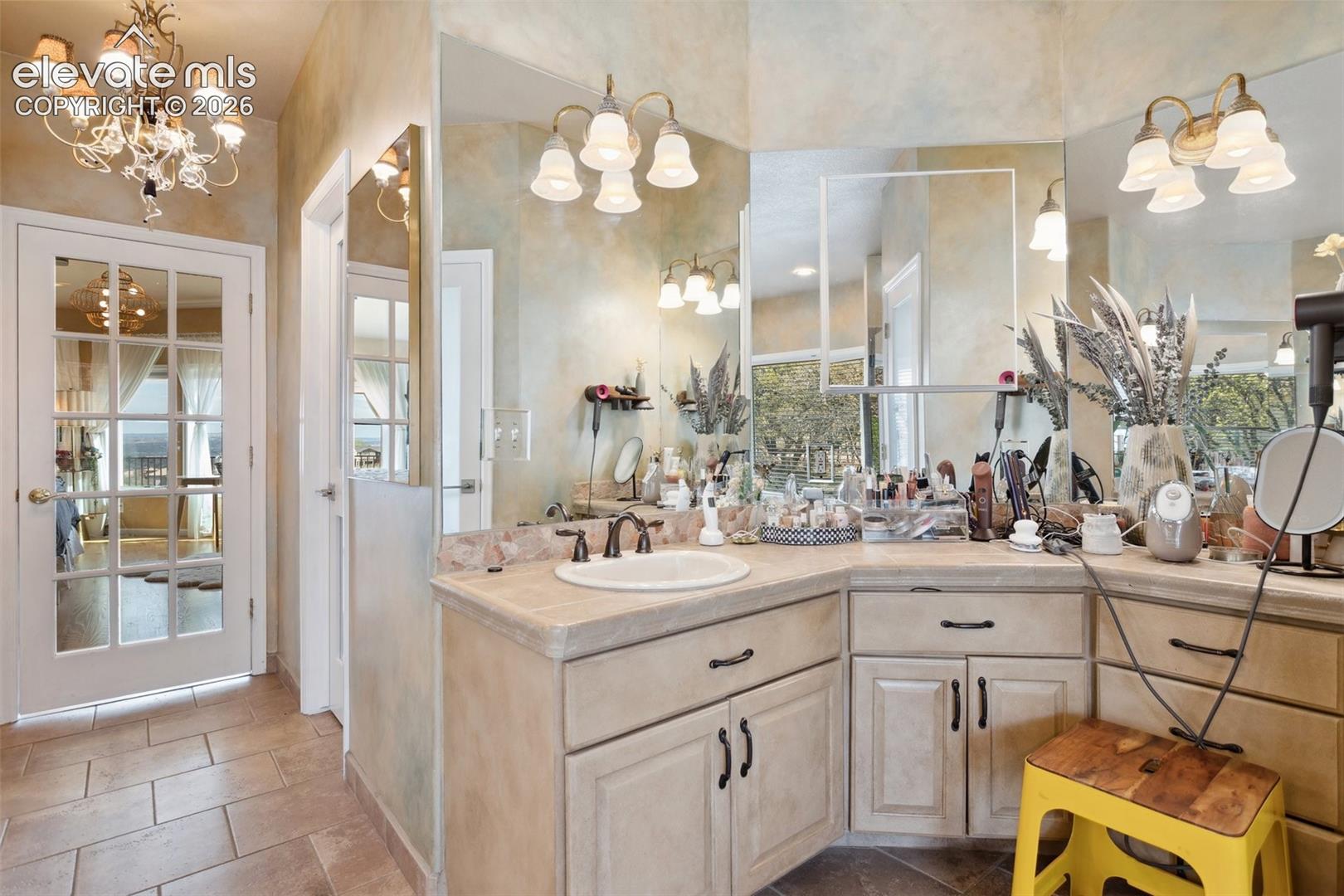 Vanity area featuring a corner sink, light-toned countertop, and multiple wall-mounted mirrors