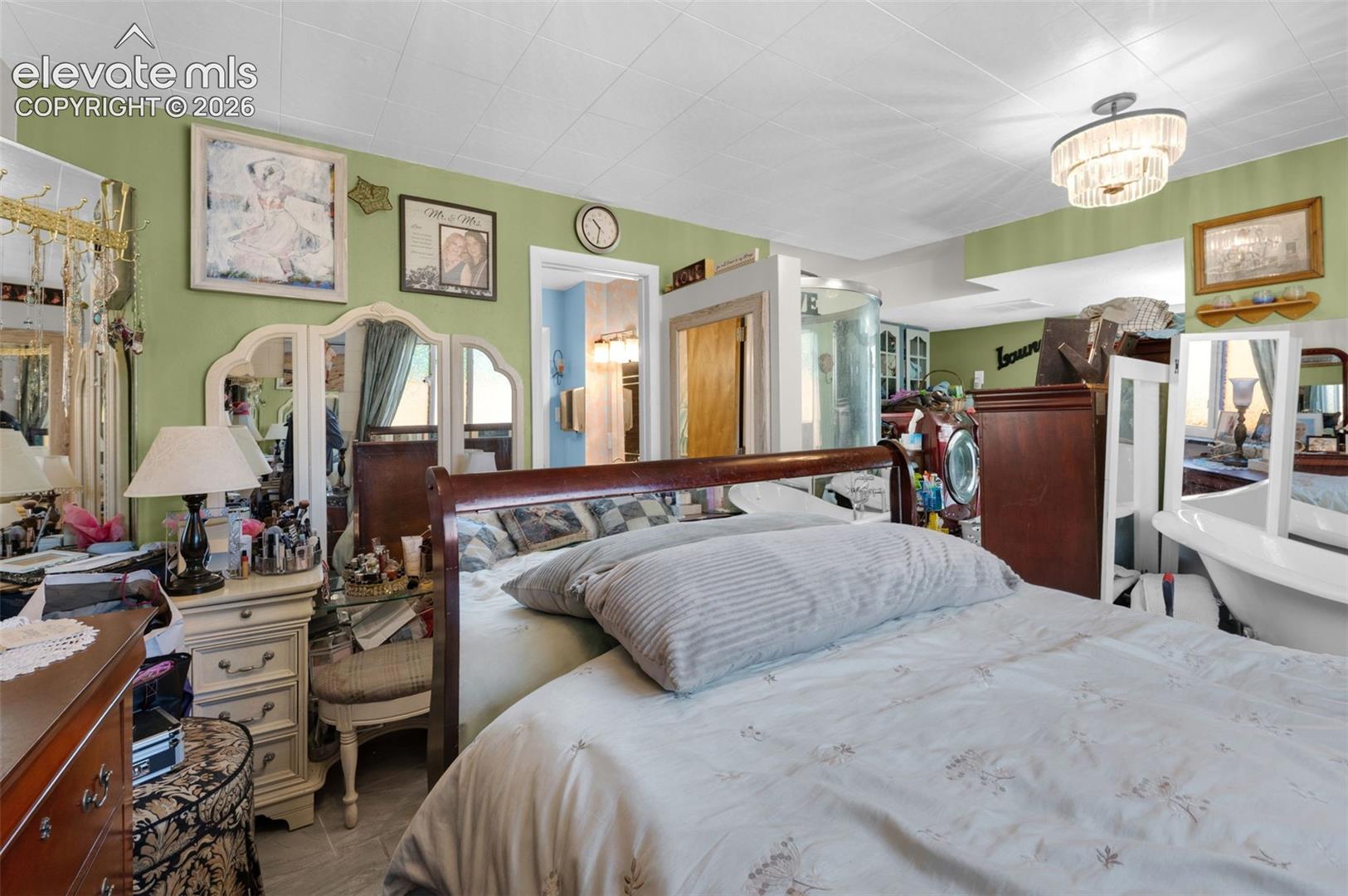 Interior room featuring a multi-tiered crystal flush-mount light fixture, a glass-enclosed walk-in shower, and tile flooring