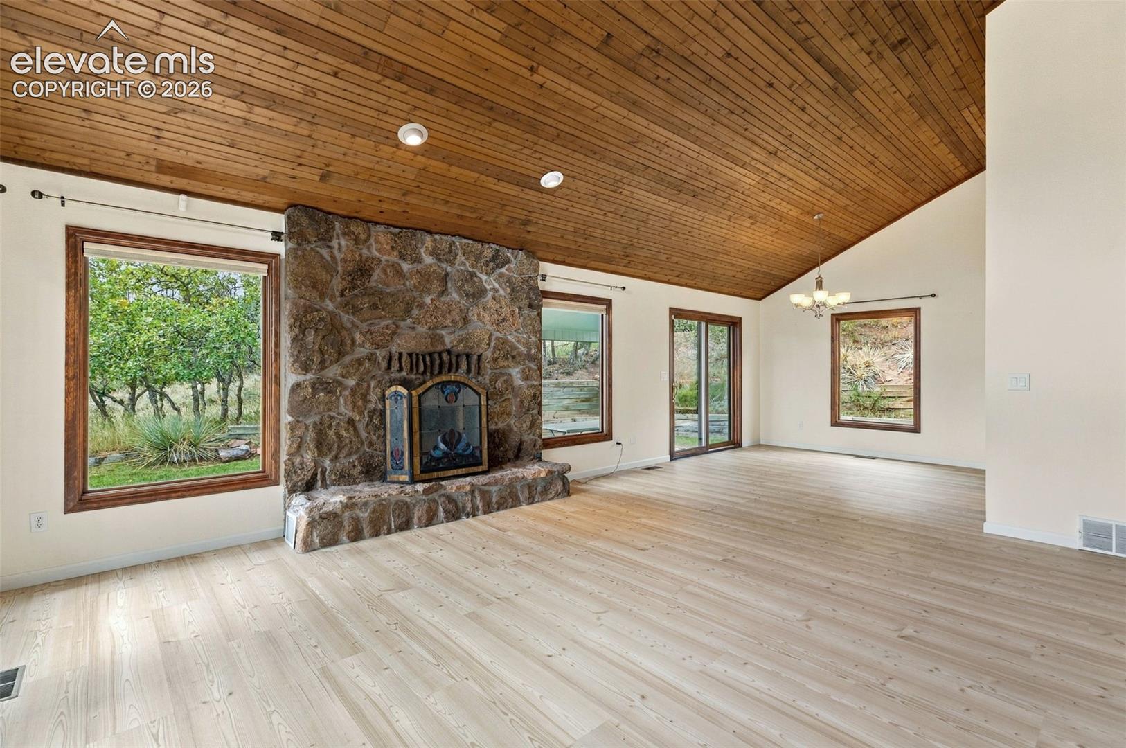 Main level living room with newer LVP flooring and wood buring fireplace.