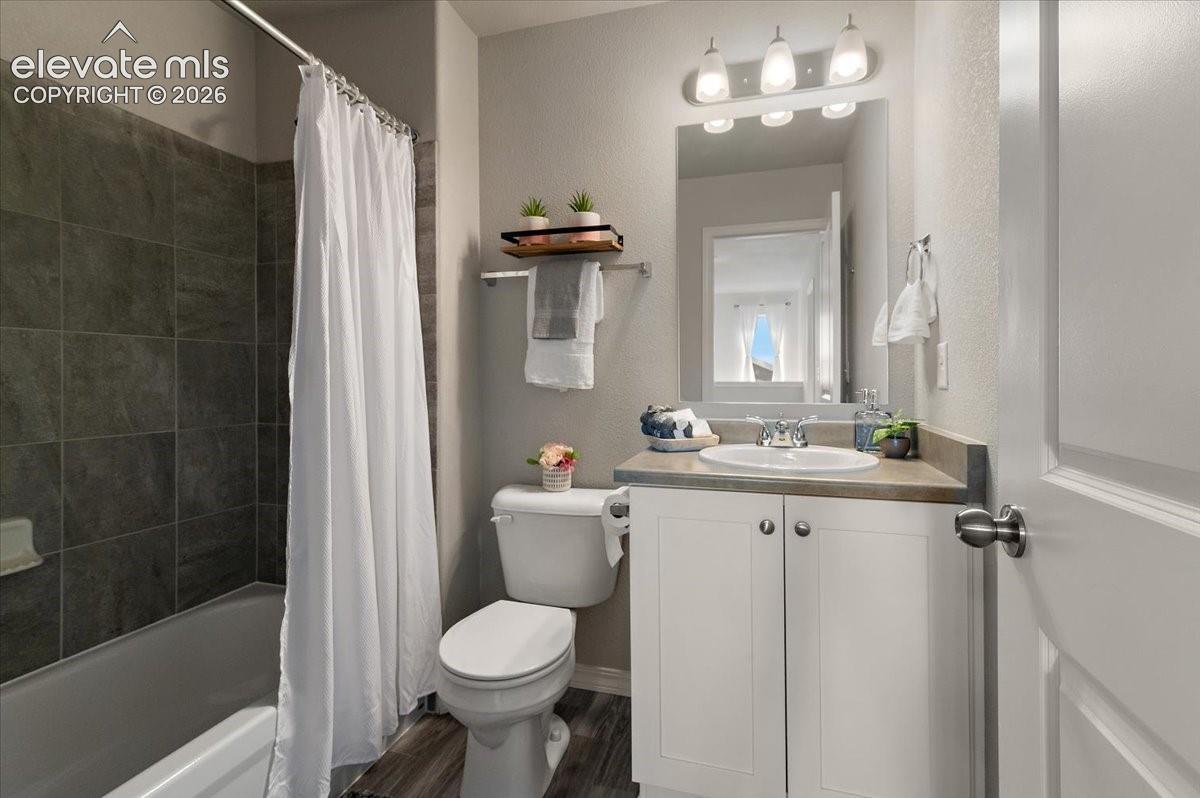 White vanity with a single basin sink and stainless-steel faucet