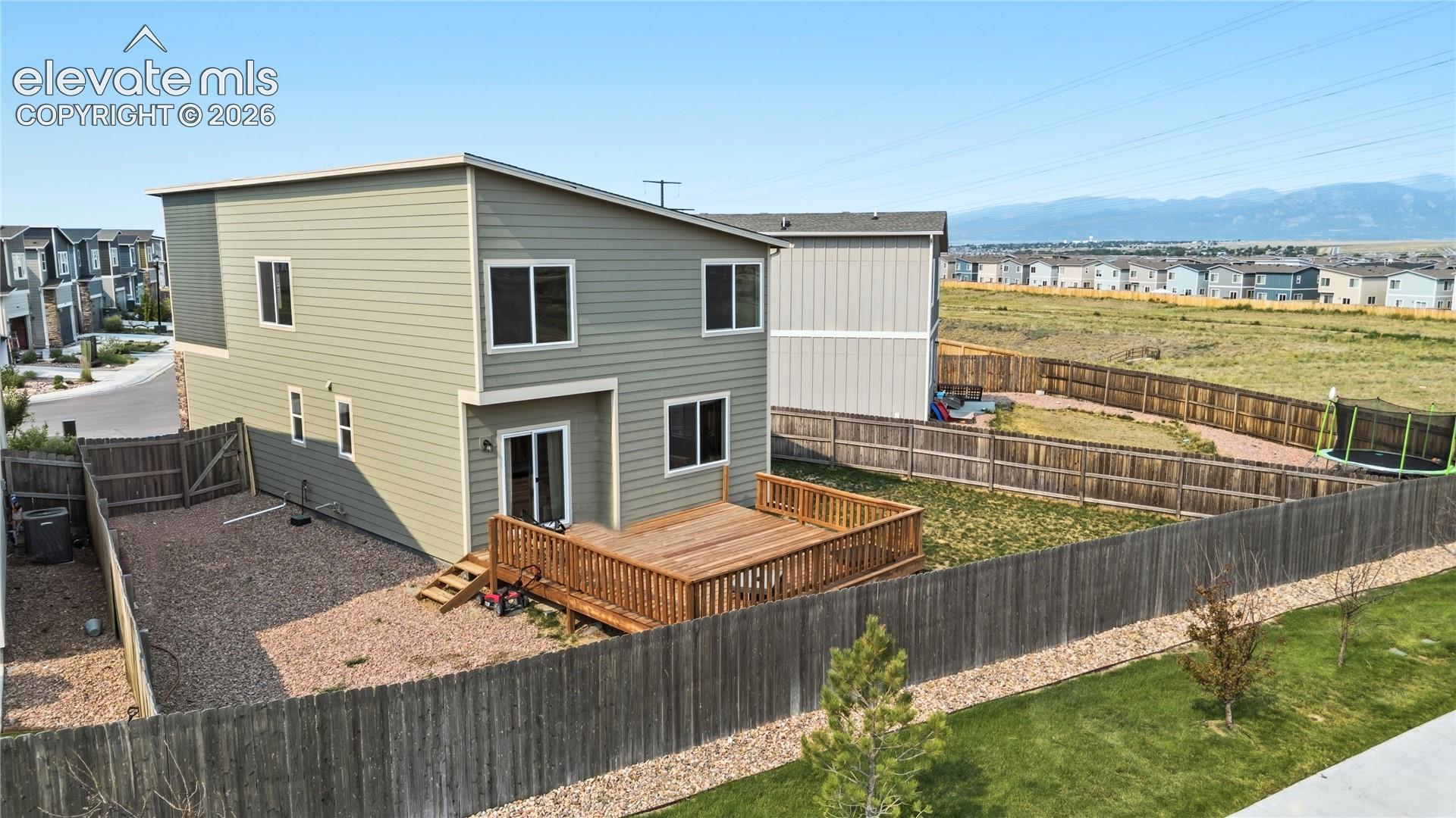 Fenced, xeriscaped backyard with wood deck and mountain views.