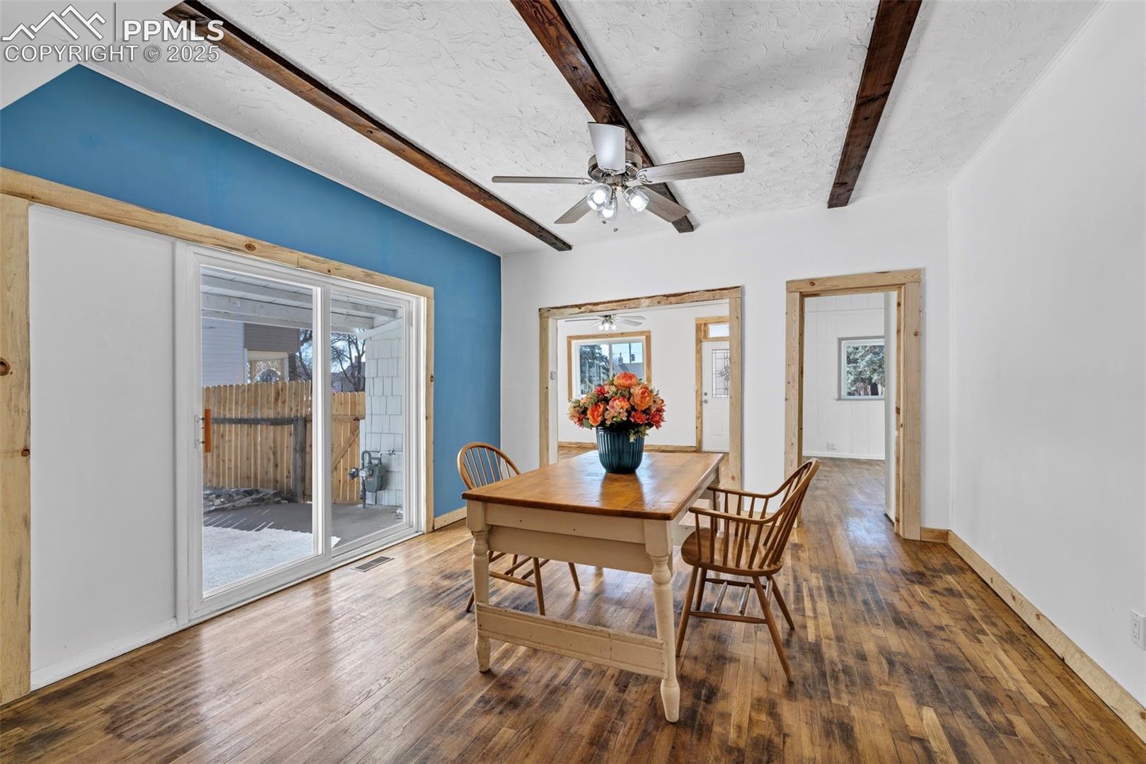 Beams and original wood floors in Dining Room, with access to White bedroom