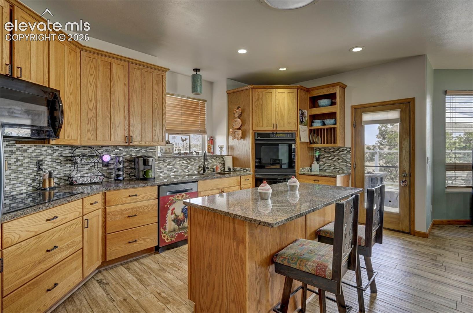 Kitchen with ceramic tile flooring, granite counters, plenty of cabinet space, and walk out to a deck with firepit