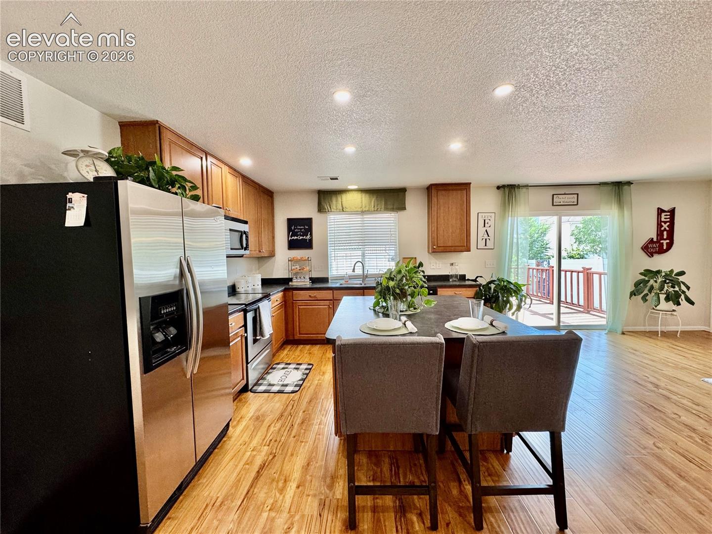 Open-concept kitchen featuring wood-finish flooring, recessed lighting, and a kitchen island with seating