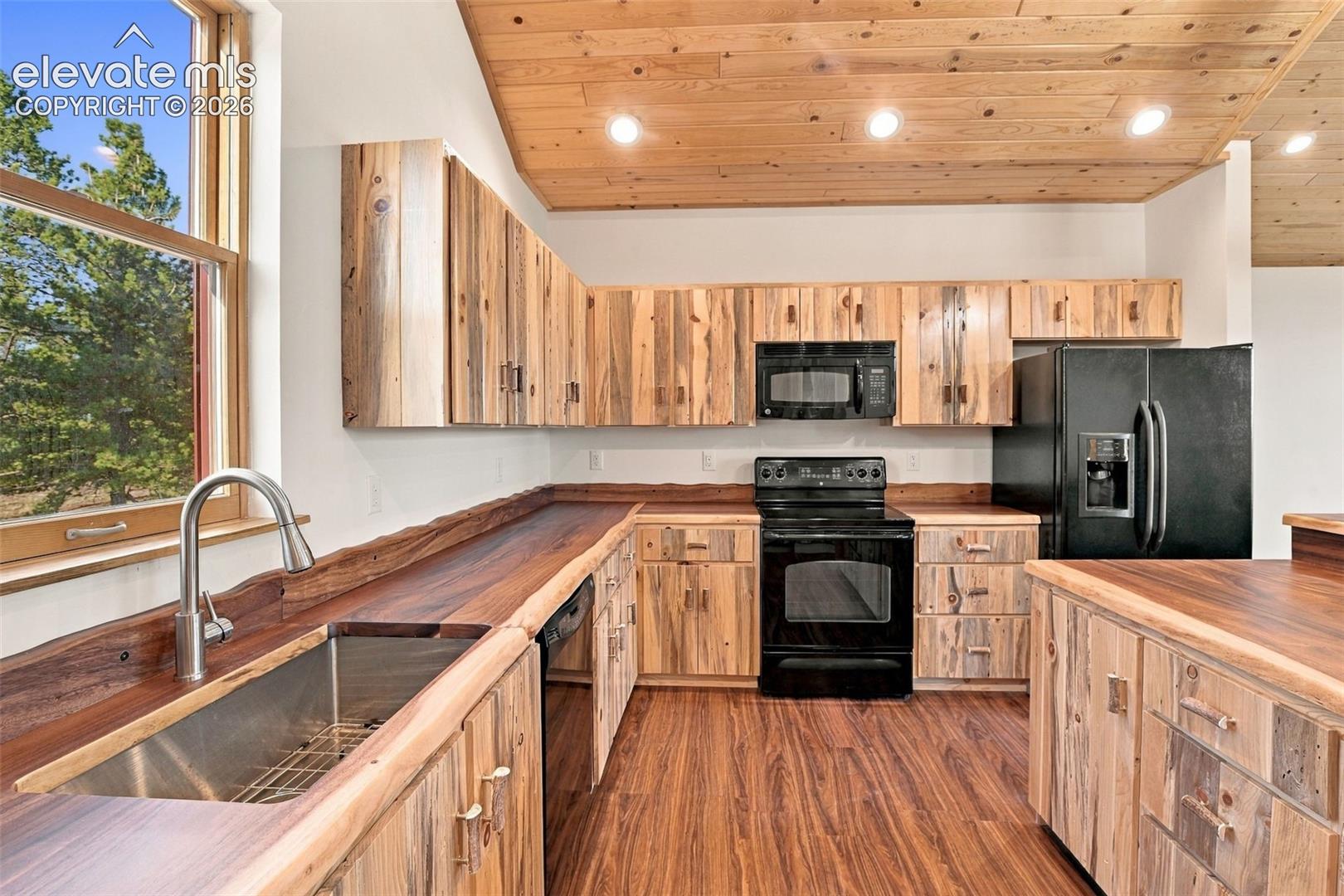 Kitchen featuring natural wood-finish cabinetry, live-edge countertops, wood-plank ceiling, and recessed lighting