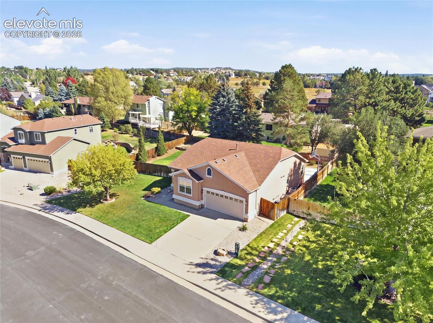Single-story residence with a two-car garage, concrete driveway, and a fenced backyard