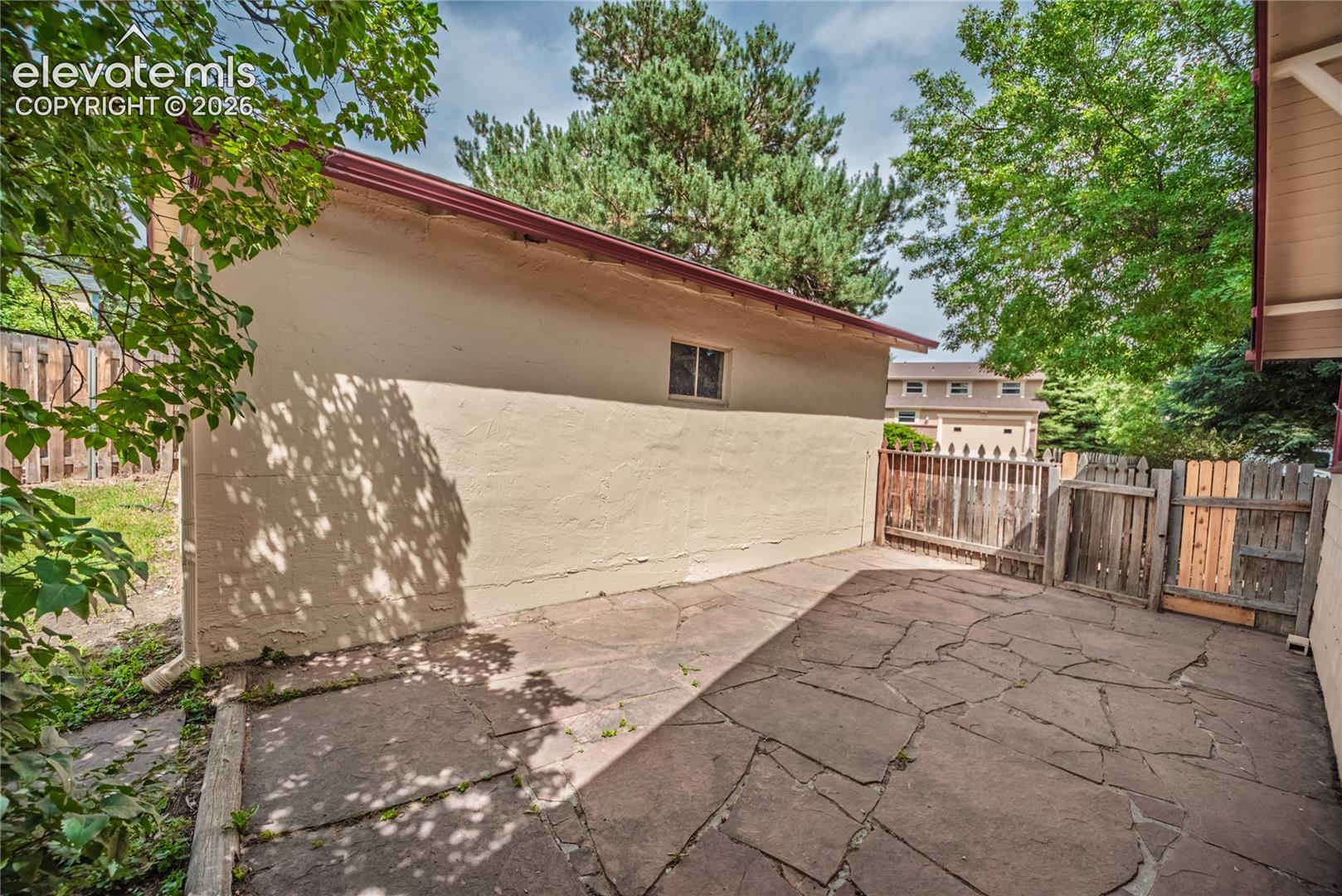 Flagstone patio with a wood privacy fence