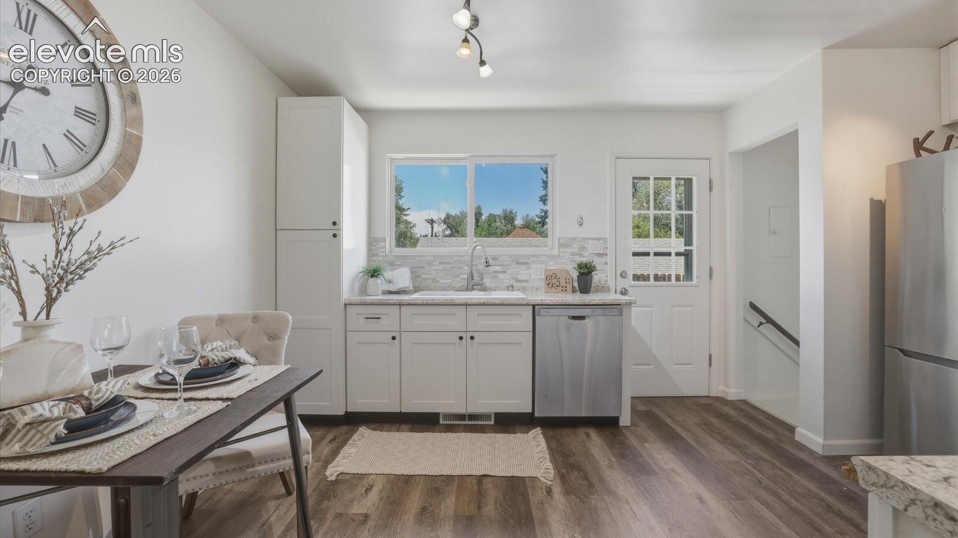 The Kitchen has a door to the backyard and stairs to the Lower Level.