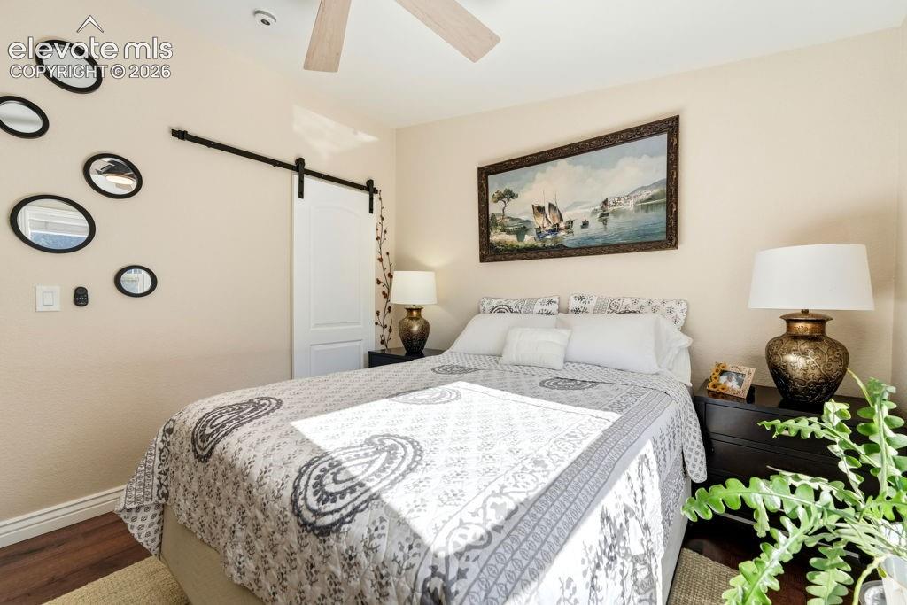 Wood-finish flooring, ceiling fan, and a barn door entry