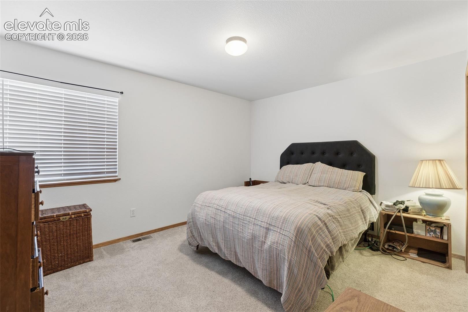 Neutral-toned interior space featuring wall-to-wall carpeting and horizontal window blinds