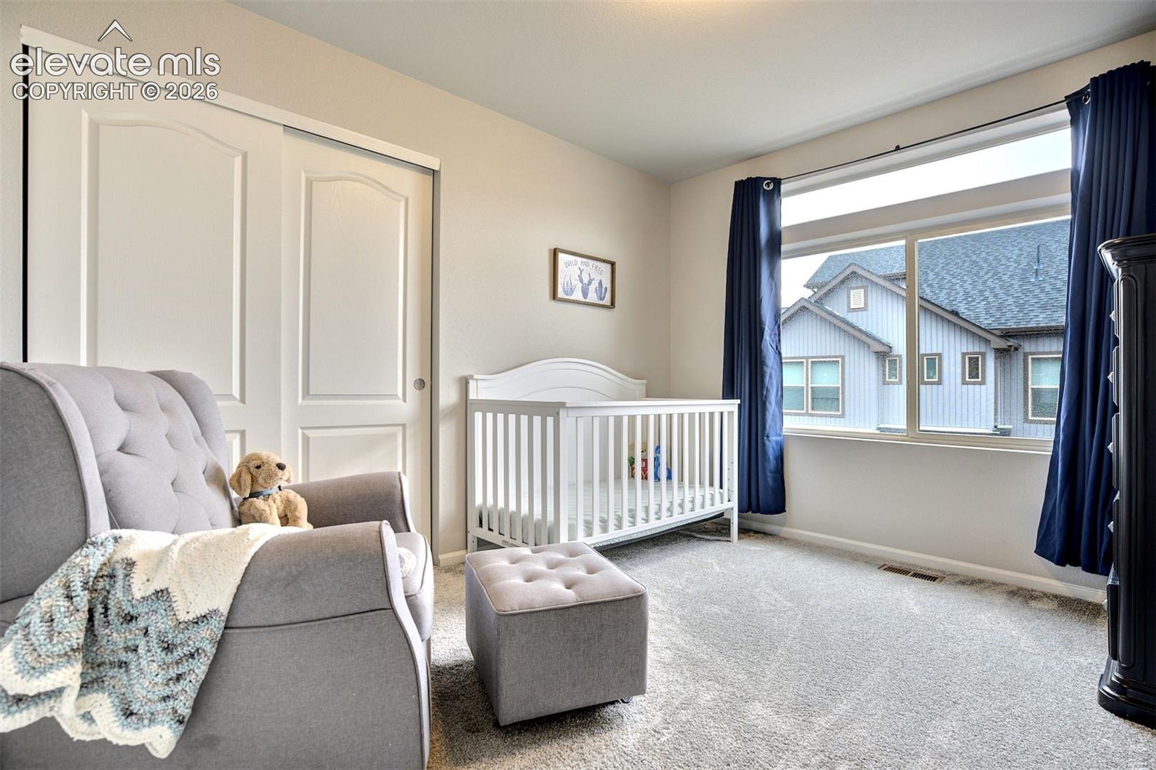 Neutral wall palette, carpeting, sliding closet doors with arched panels, and a large horizontal window with transom